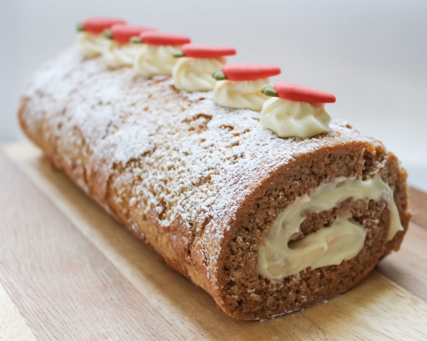 Fully decorated carrot cake Swiss roll with cream cheese frosting/icing