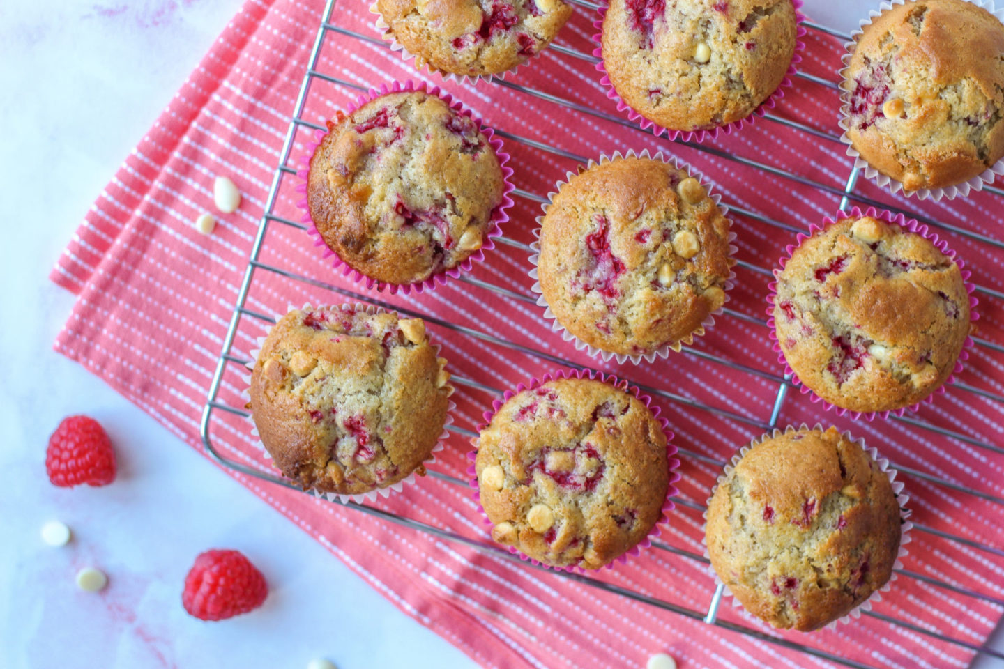 baked raspberry white chocolate muffins on a wire rack