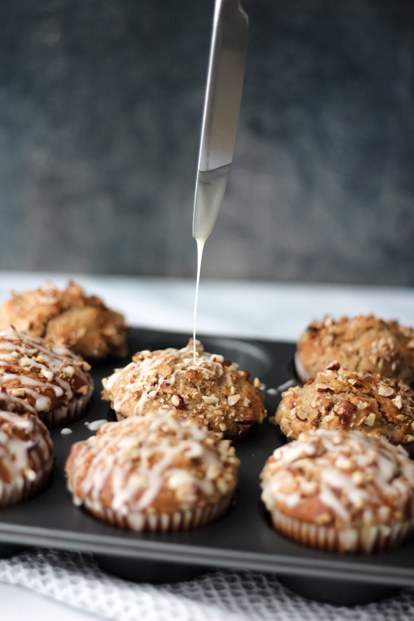 drizzling the icing on top of muffin