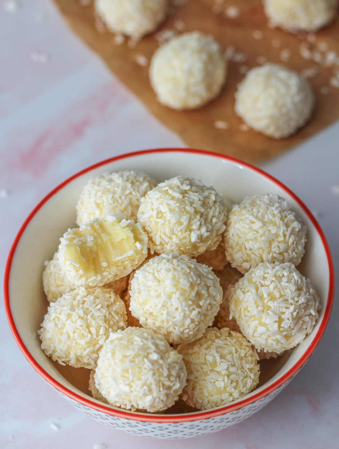 bowl of white chocolate coconut truffles with bite taken out of one