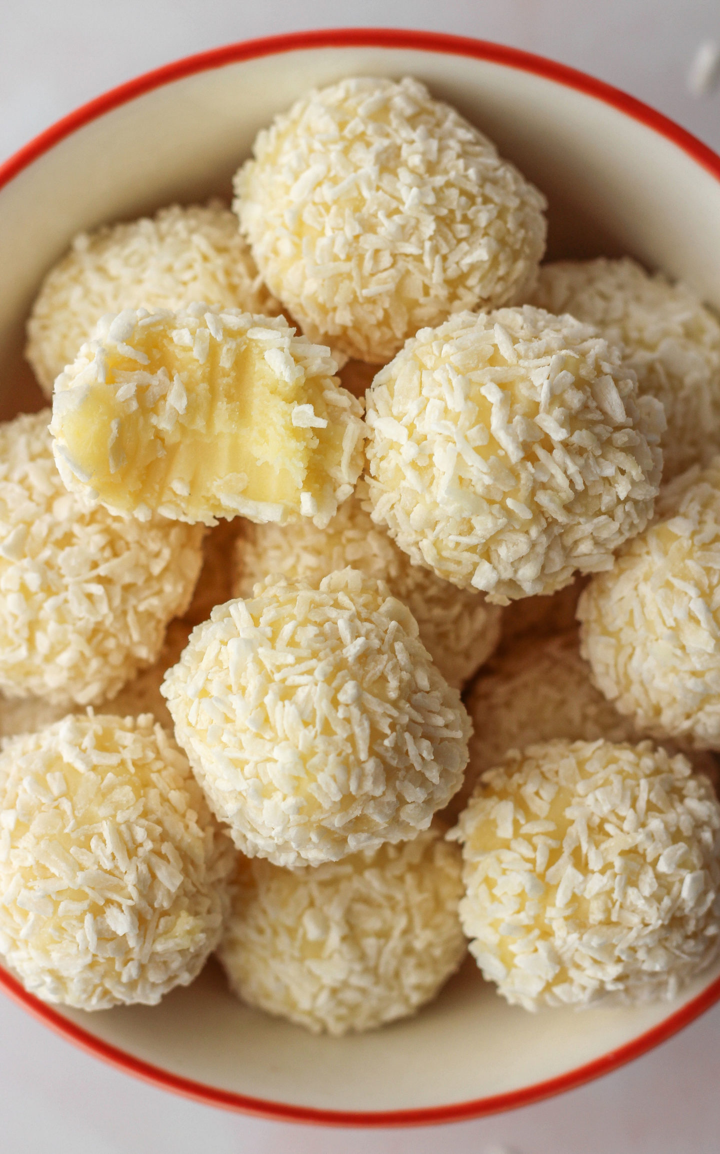 close up of white chocolate coconut truffles with bite taken out of one