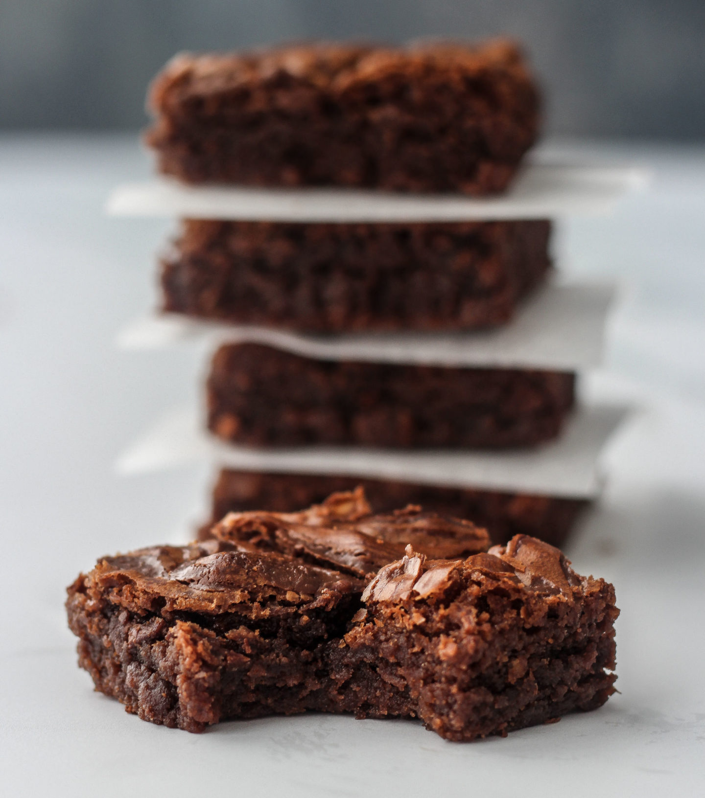 close up of nutella brownie with bite taken out of it and tower of brownies in background