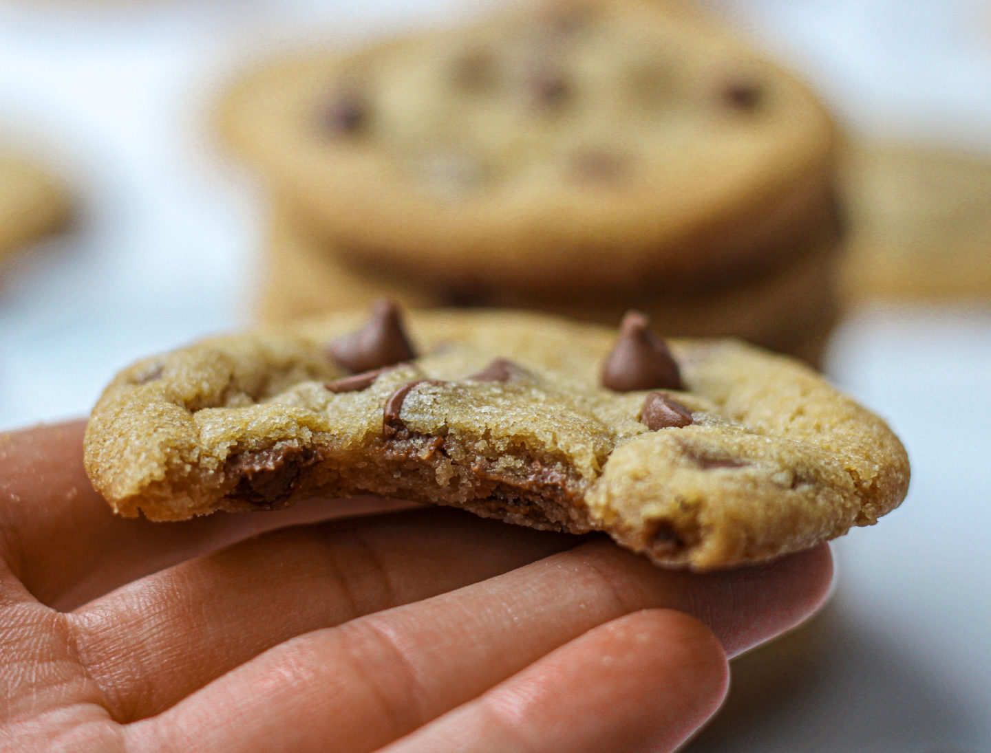 close up of chewy chocolate chip cookie with bite taken out of it 