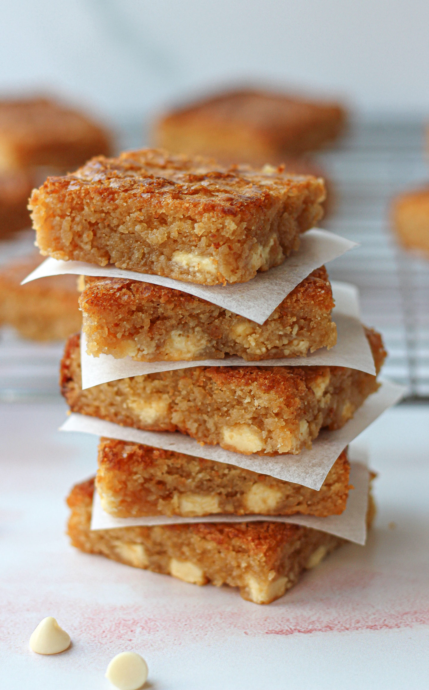 tower of five white chocolate blondies with pieces of parchment paper in between each