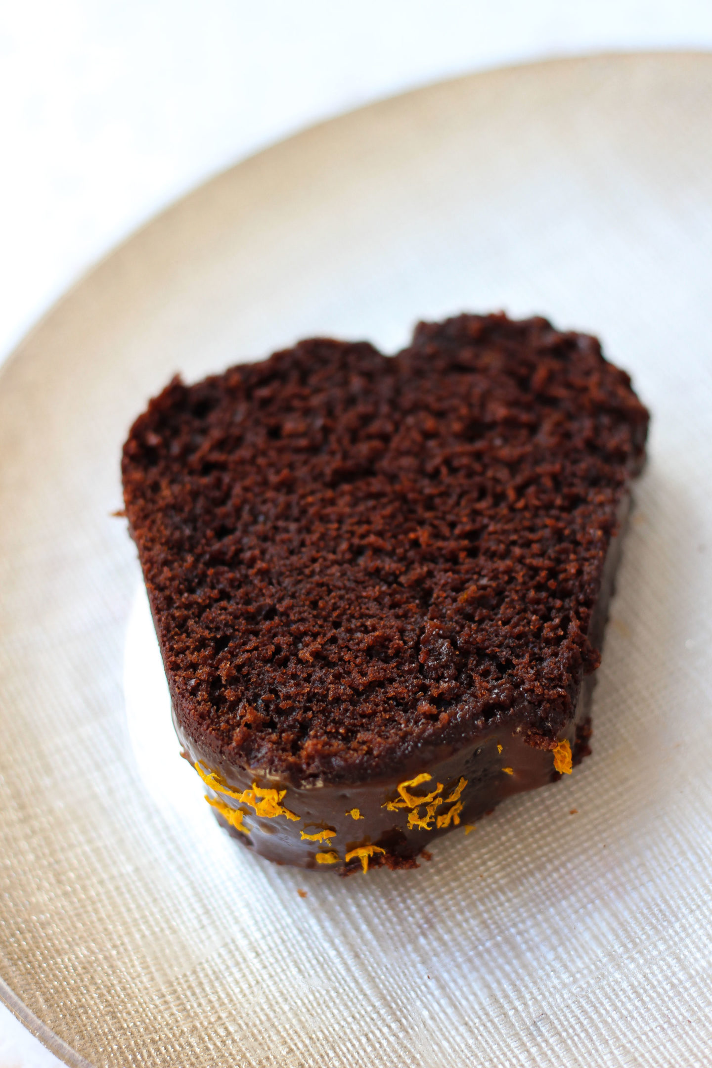Close up of slice of chocolate orange Bundt cake on a plate