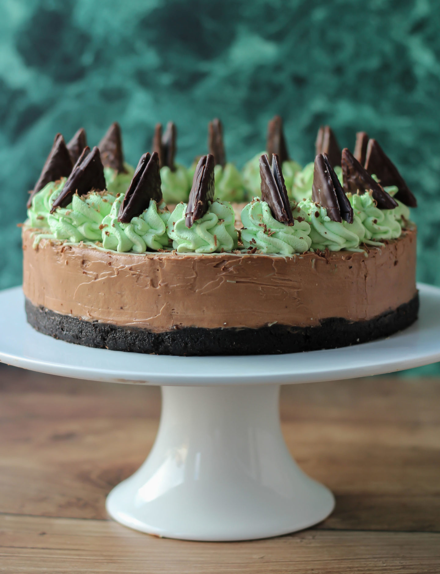 Whole no-bake mint chocolate cheesecake on cake stand