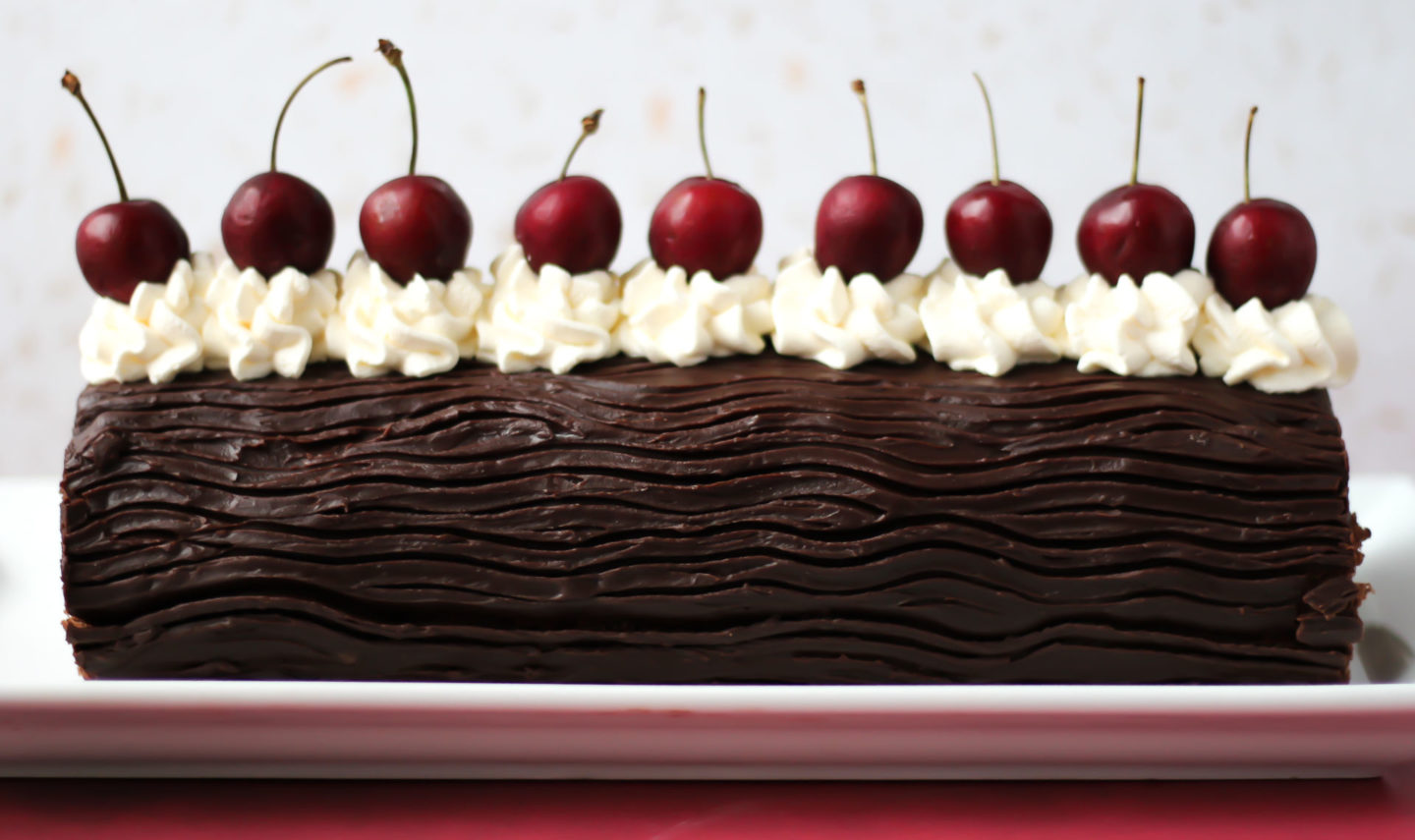 side on view of unsliced black forest swiss roll