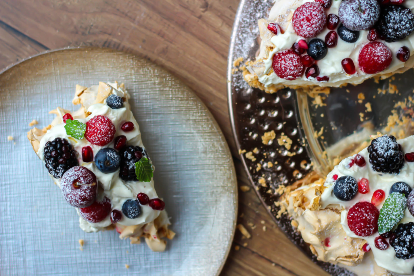 view from above of a slice of Christmas berry pavlova wreath next to the cut wreath