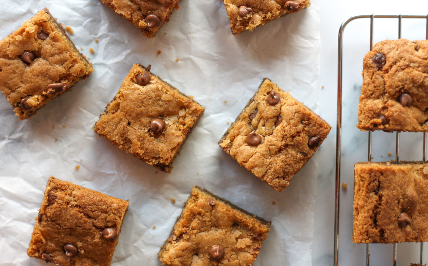 overhead view of chewy chocolate chip cookie bars on parchment paper