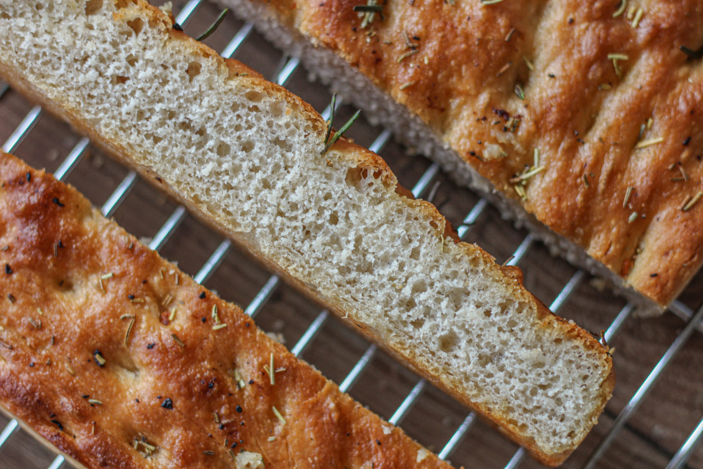 long slice of garlic and rosemary focaccia on its side. showing the texture inside