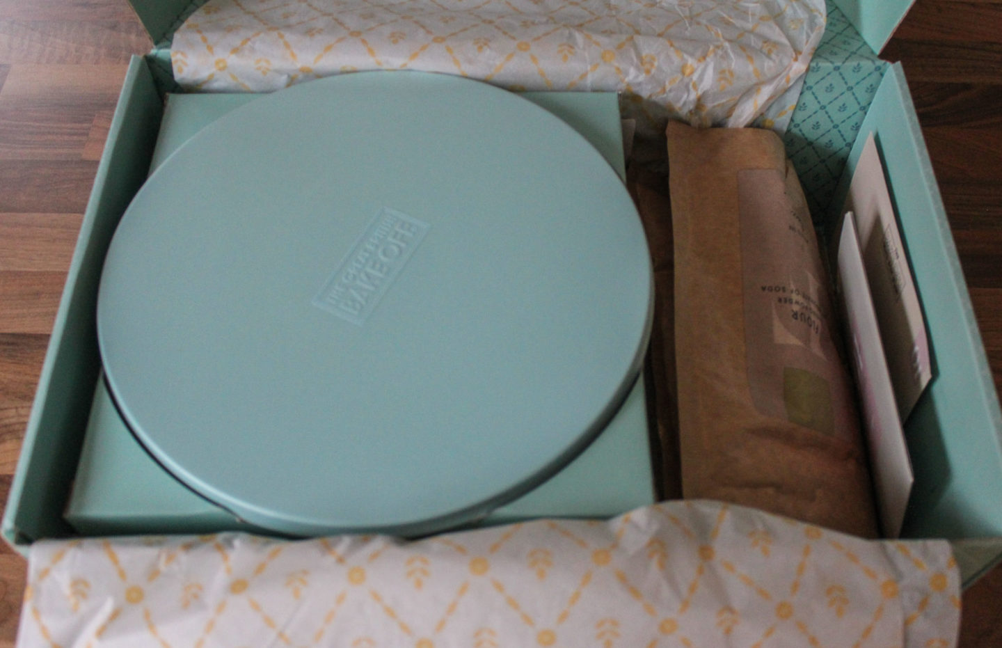 Inside of Bake Off Box showing the cake stand, bags of dry ingredients and recipe card