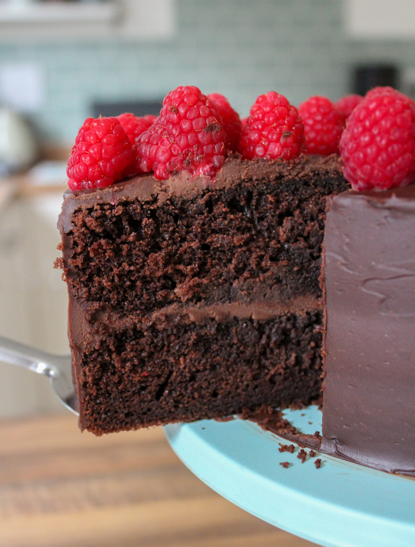 close up of slice of signature chocolate cake being removed from the cake on cake stand