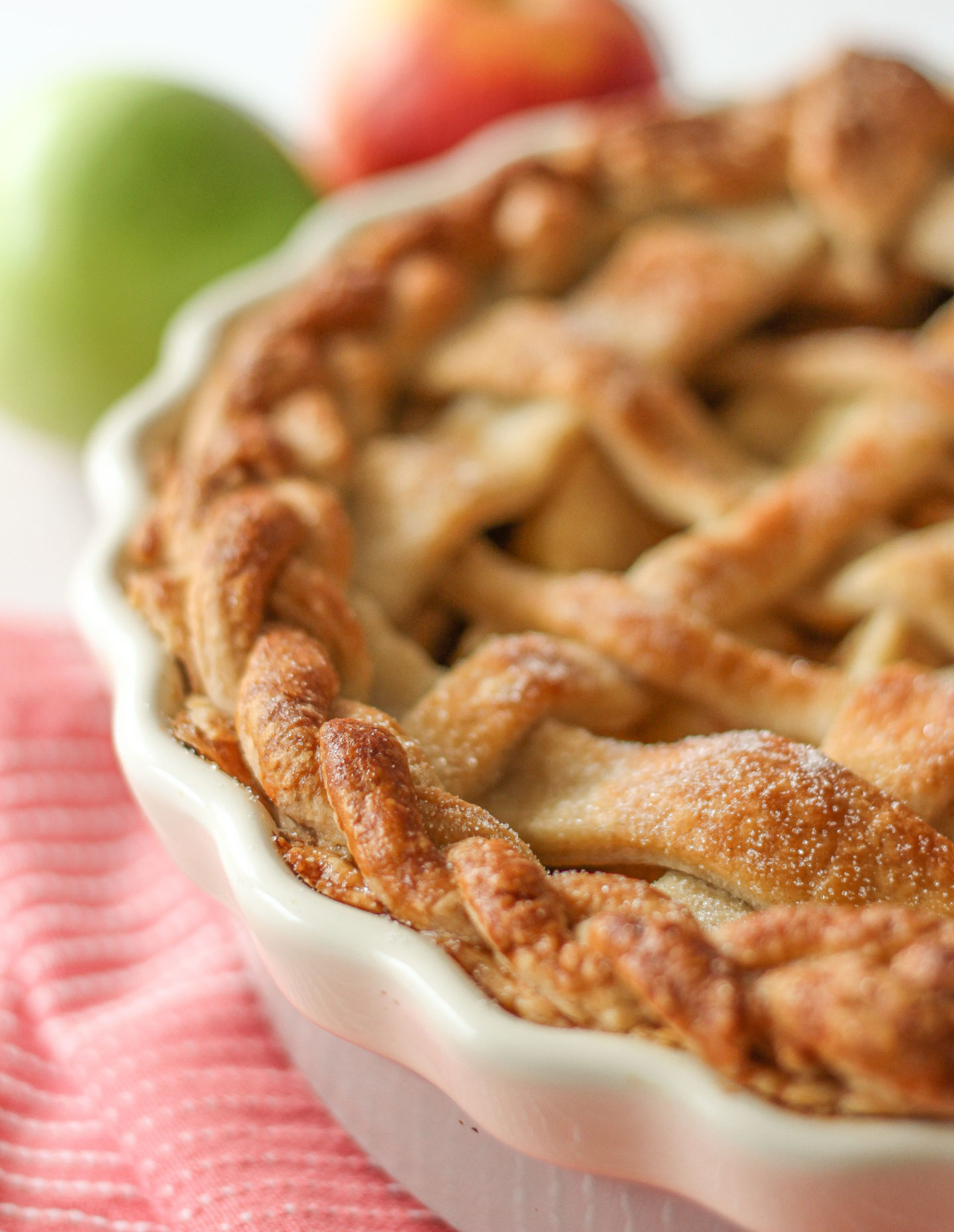 close up of unsliced lattice apple pie, focussed on the plaited crust