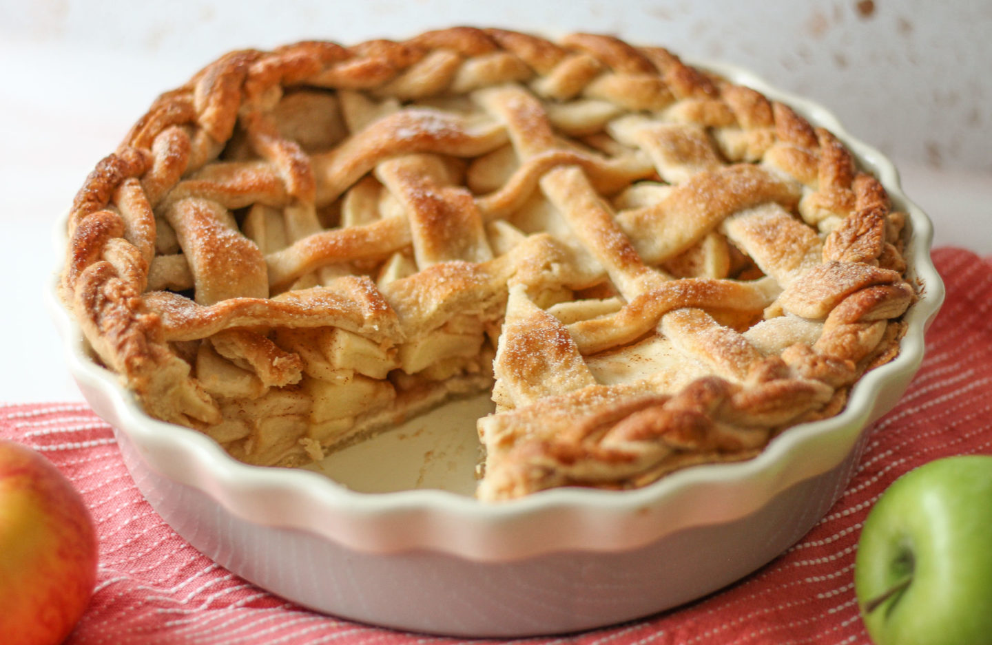 whole lattice apple pie with slice taken from it, showing the filling inside