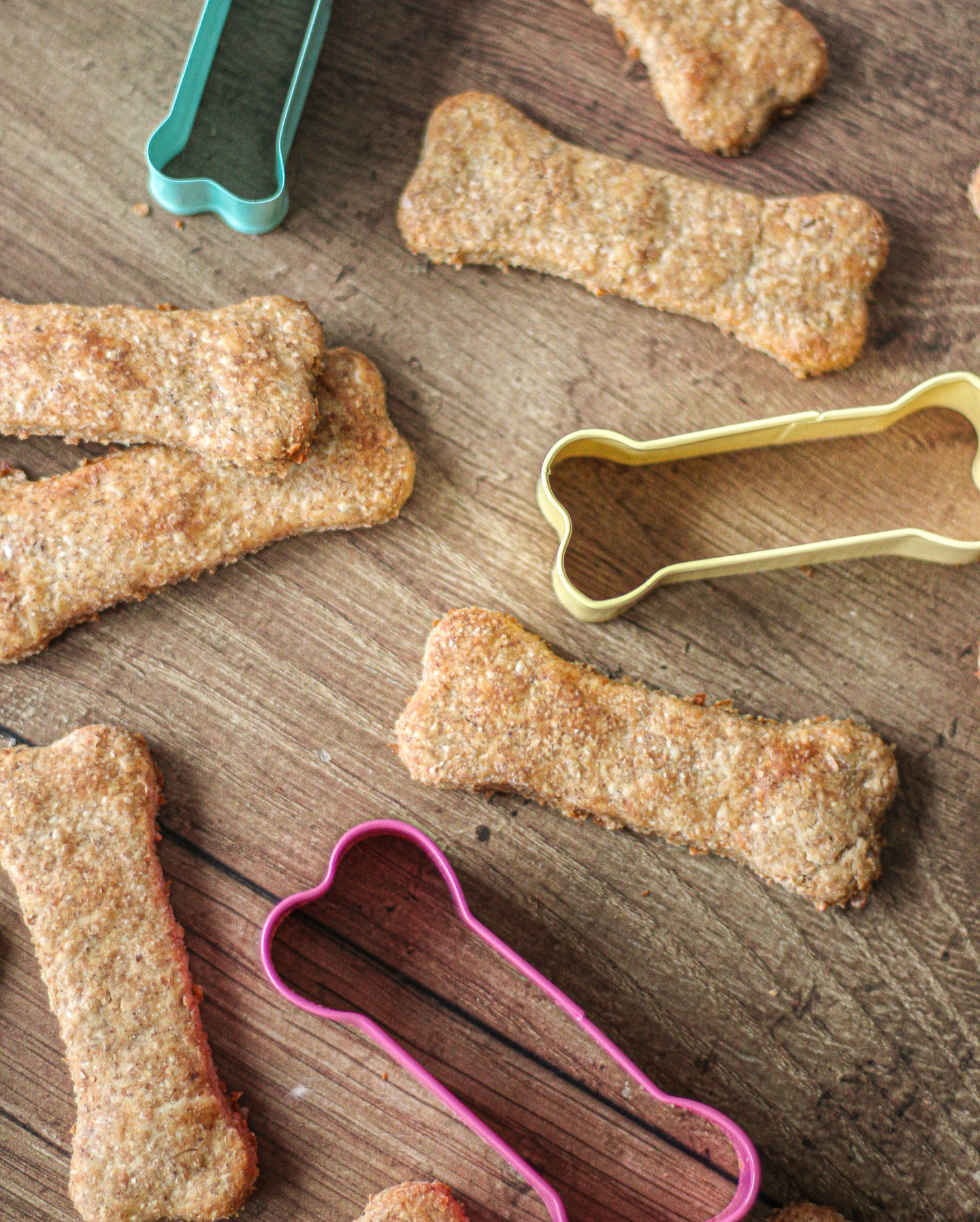 View from above of peanut butter banana dog treats with dog bone shaped cutters between them