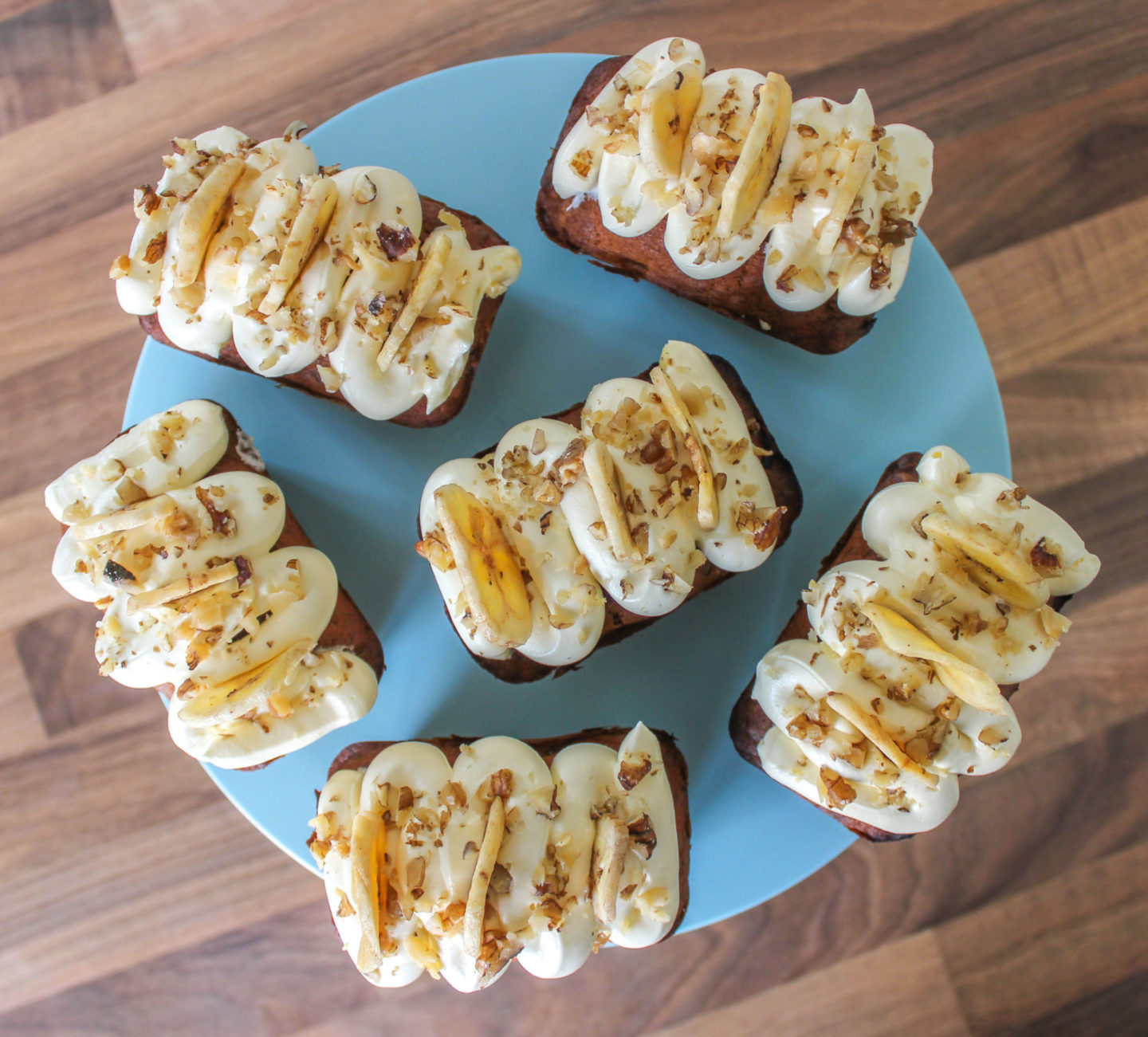 view from above of several banana and walnut mini loaves on a blue cake stand