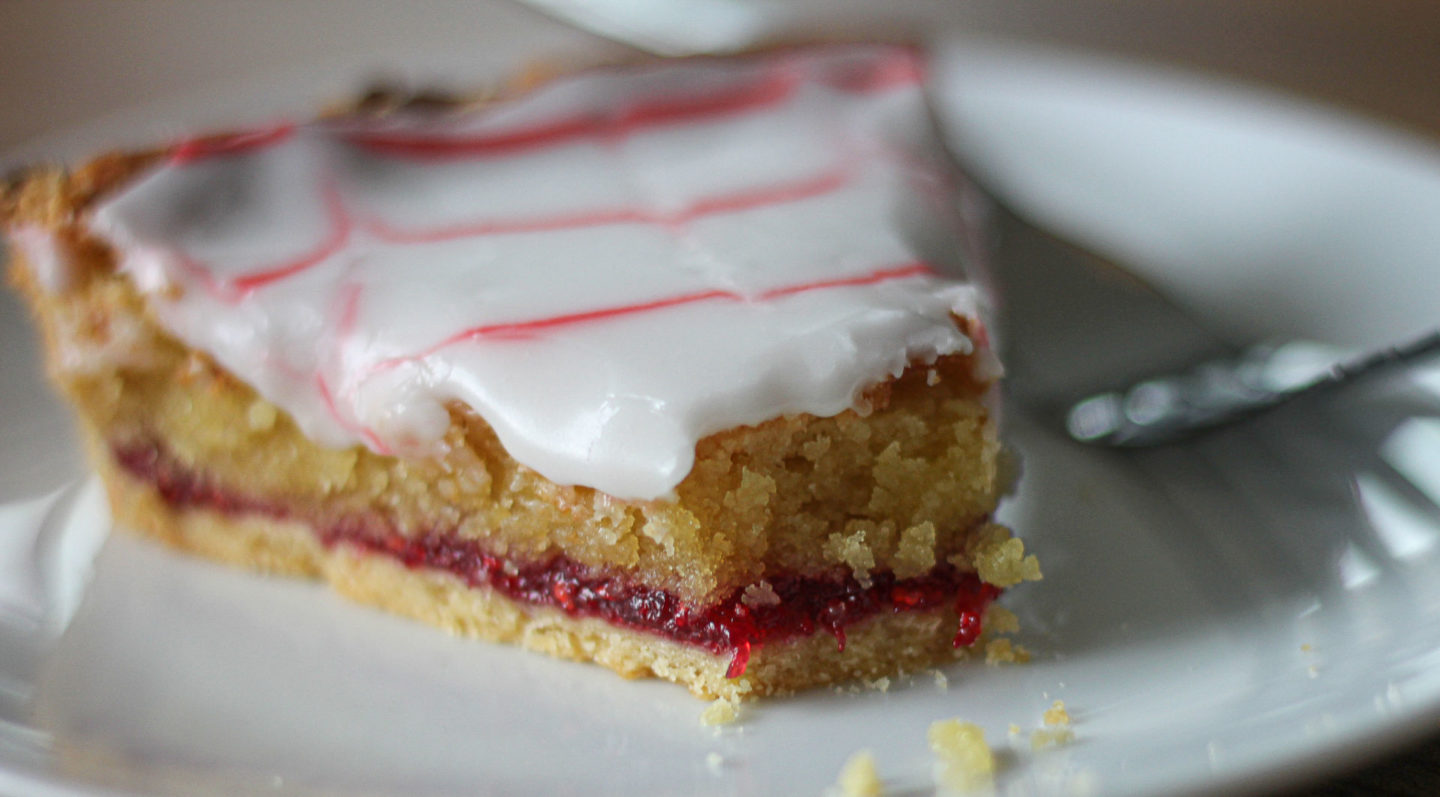 close up of a slice of bake off box Bakewell tart on a small serving plate with a fork