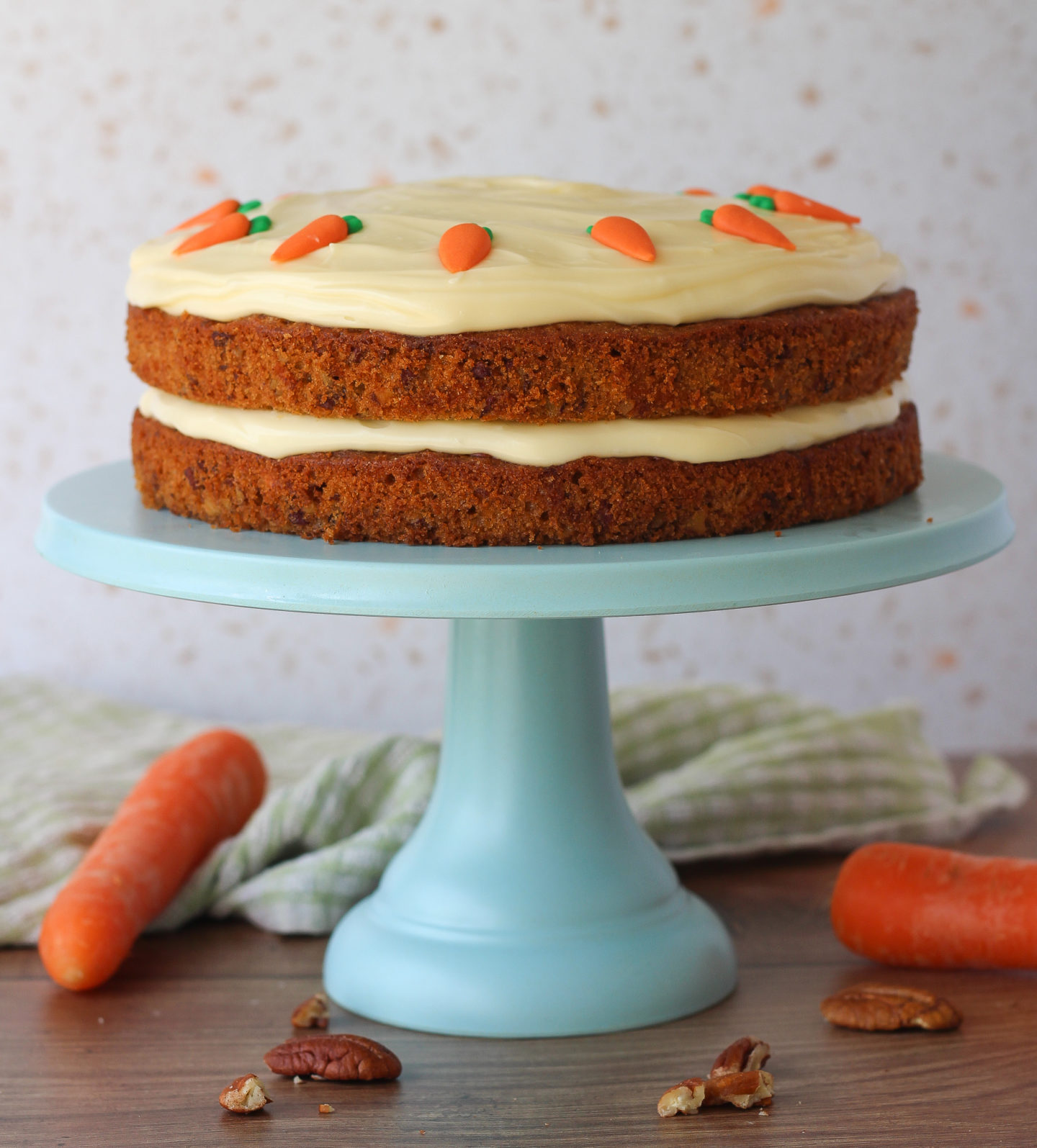 whole unsliced carrot cake on top of blue cake stand